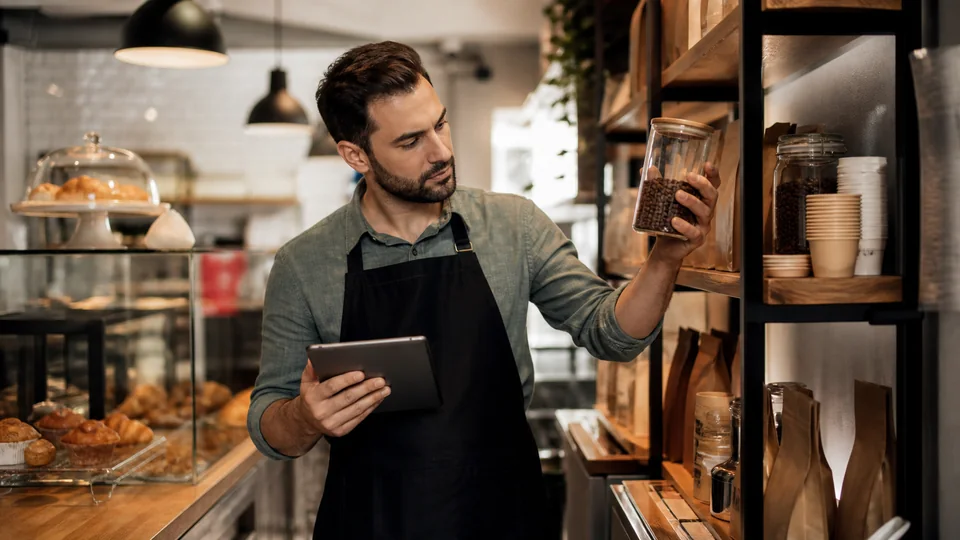 Coffee shop manager reviewing supplies, pastries and stock levels