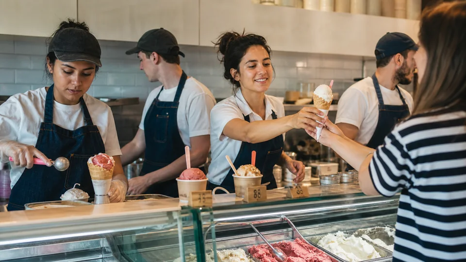 Ice cream shop team coordinating orders between counter and preparation